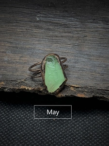 Macro detail of vintage adjustable ring featuring an irregular green May birthstone