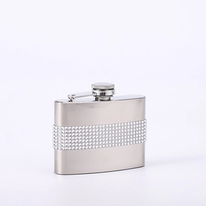 Detailed close-up of a stainless steel hip flask featuring a sparkling rhinestone band wrap