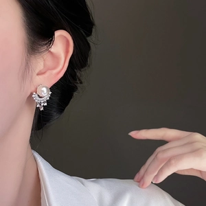 Detail of silver needle pearl earrings with shimmering diamond tassel fringe on model