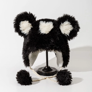 Detail of plush bear ear hat with white heart pattern and fuzzy pompom drawstrings