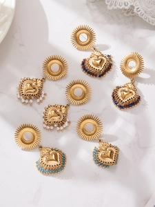 Détail de boucles d'oreilles cœur en or 18 carats avec perles blanches et perles colorées