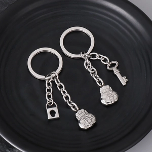 Detail of stainless steel couple keychains with lock, key, and lucky bag charms