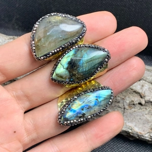 Detail of three labradorite rings with blue flashes and gold plating on hand