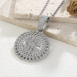 Gros plan d'un collier avec pendentif signe dollar argenté et cristaux sur chaîne torsadée