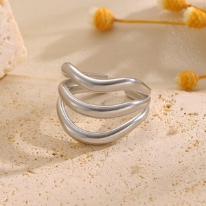 Gros plan sur bague ouverte en acier inoxydable argenté avec motif vagues à trois plis