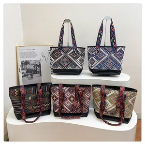 Detail view of five ethnic canvas tote bags with colorful geometric patterns and leather bases