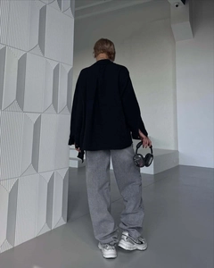 Rear view of urban casual loose fit black shirt jacket and grey straight leg pants