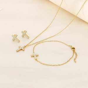 Detailed view of a gold cross jewelry set featuring a necklace, bracelet and earrings