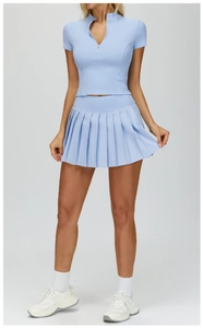Detail of light blue yoga set featuring a zip-up slim fit top and pleated tennis skirt