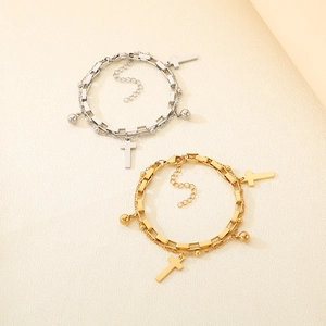 Detail of 18K gold and silver layered cross bracelets with round beads and link chain