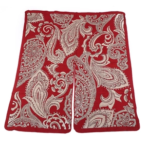 Detailed close-up of red paisley patterned scarf fabric showing intricate ethnic motifs