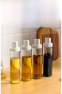 Detail of four thick lead-free glass oil dispensers with white press-style caps