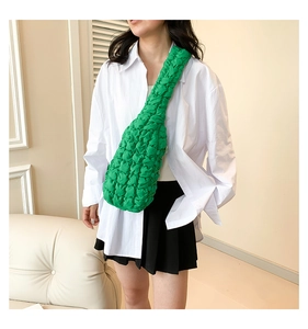 Détail de la texture gaufrée verte sur un sac à bandoulière minimaliste de type nuage
