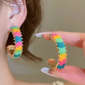 Rainbow knit C-shaped hoop earrings with colorful stripes and beaded metal edges