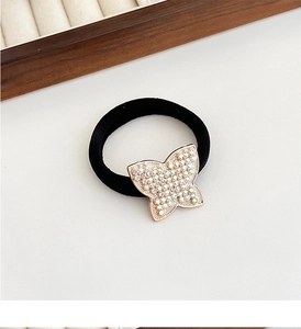 Detail of high-elastic black hair tie with rhinestone-encrusted butterfly charm