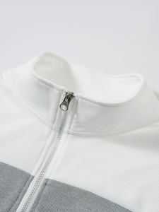 Détail de maille gaufrée et fermeture éclair argentée sur pull col blanc et gris