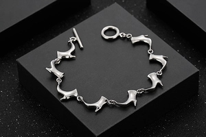 Détail d'un bracelet argenté aux maillons bottines avec fermoir à bascule sur boîte
