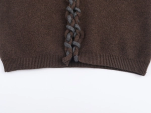 Gros plan d'un cardigan en maille marron avec bord-côte et détails de tressage épais