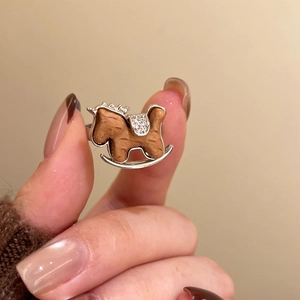 Detail view of the rocking horse ring featuring wooden texture and inlaid zircons