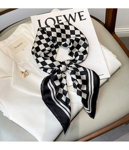 Fashionable black and white checkered silk scarf styled on a white blazer collar