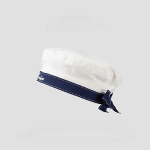 Detail of white beret featuring navy blue ribbon, delicate bow and floral embroidery