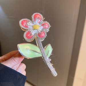 Détail macro d'une pince à cheveux fleur émaillée avec cristaux scintillants