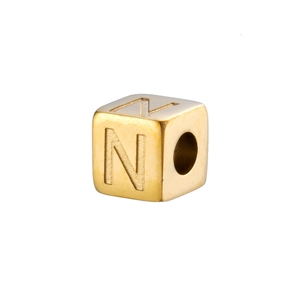 Macro shot of 14K gold plated stainless steel cube bead with engraved letter N for DIY