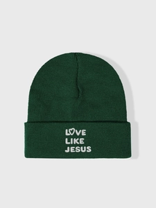 Detailed close-up of Love Like Jesus white embroidery on green knit beanie hat