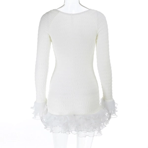 Detailed view of cream smocked fabric texture and layered tulle hem on long sleeve dress
