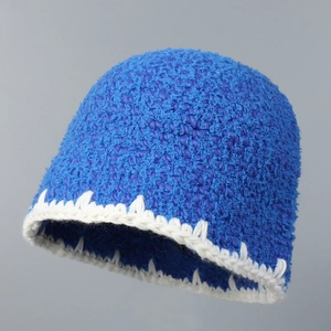 Detailed close-up of blue knit beanie featuring contrasting white zigzag hand-stitched hem