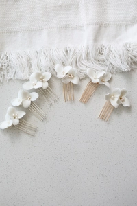 Detailed set of white ceramic flower and pearl bridal hair pins in gold and silver