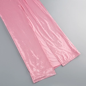Detail view of pink sequin fabric and elegant side slit on a long strap dress