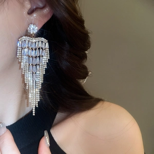 Close-up of sparkling silver tassel earrings with zircon flower detail on model
