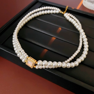 Macro view of 18k gold-plated square clasp with mother-of-pearl on pearl necklace