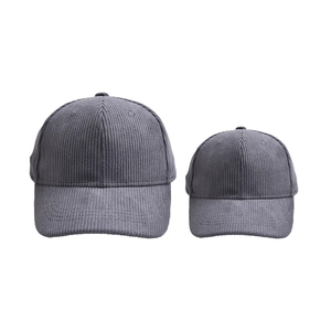 Detail of dark grey corduroy fabric texture on matching parent and child baseball caps