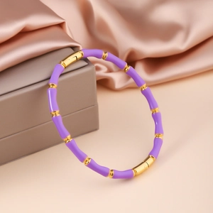 Detail eines lila Emaille-Armreifs im Bambus-Stil mit goldenen Metallgelenken und Verschluss
