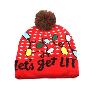 Detail of red knit Christmas beanie with reindeer pattern and Let's Get Lit slogan