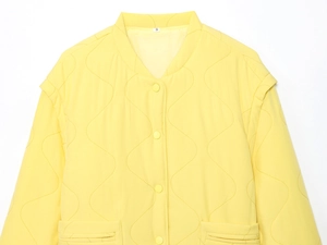 Detail of yellow quilted jacket showing wavy stitching and matching snap buttons
