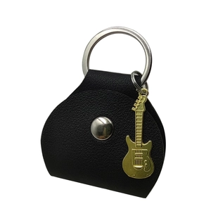 Close-up of black leather guitar pick pouch with golden guitar charm and silver ring