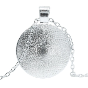 Detail view of round silver dragon eye necklace pendant with textured geometric back pattern