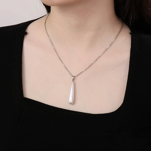 Elegant white teardrop pearl pendant on a silver steel necklace worn by a model