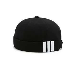 Black cotton docker cap with white side stripes and button top in minimalist street style