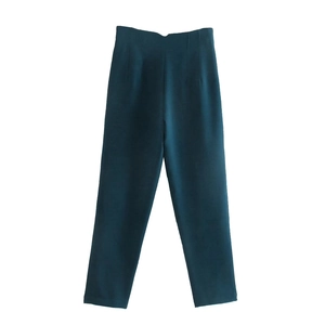 Dettaglio del tessuto verde scuro liscio e del taglio sartoriale dei pantaloni corti