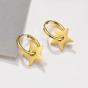 Detail shot of golden stainless steel hoop earrings with polished star pendants