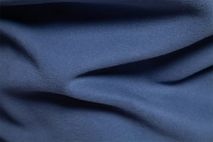 Macro view of navy blue knitted fabric texture showing soft material on men's sweatshirt