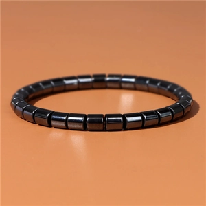 Detailed view of black cylindrical hematite beads bracelet with a metallic sheen finish