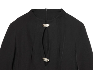 Détails de robe noire évidée avec boucles en strass argentés et tissu texturé chic