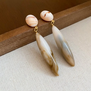 Detail view of retro marble-pattern drop earrings with golden links and acrylic stones