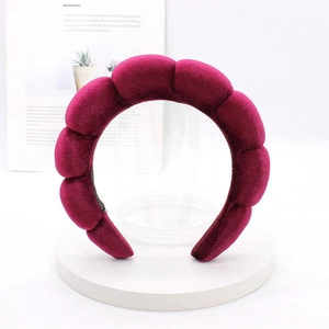 Detail of burgundy velvet padded headband with bubble design on a white display stand