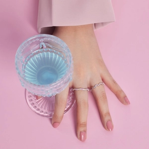Detailed view of S925 sterling silver colorful zircon wavy rings worn by a model